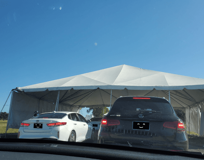 Cars driving through one of the tents at the Homestead Air Reserve Covid drive thru testing center.