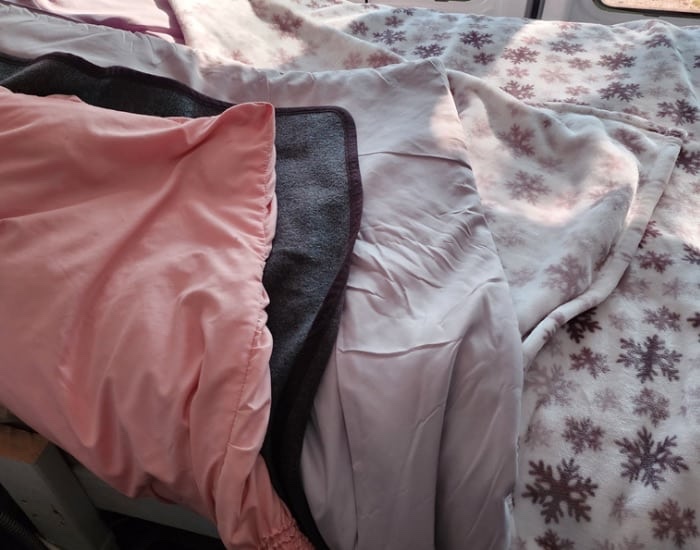 Layering blankets to stay warm. Van life.