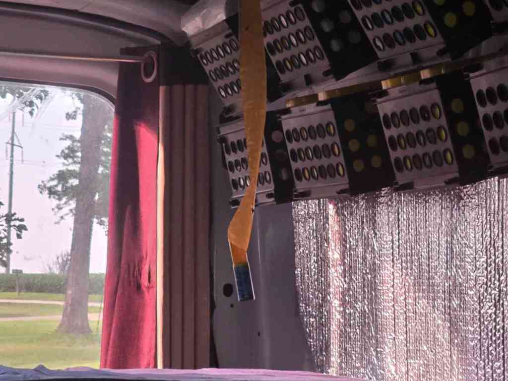 A sticky fly strip hanging over my van life bed.